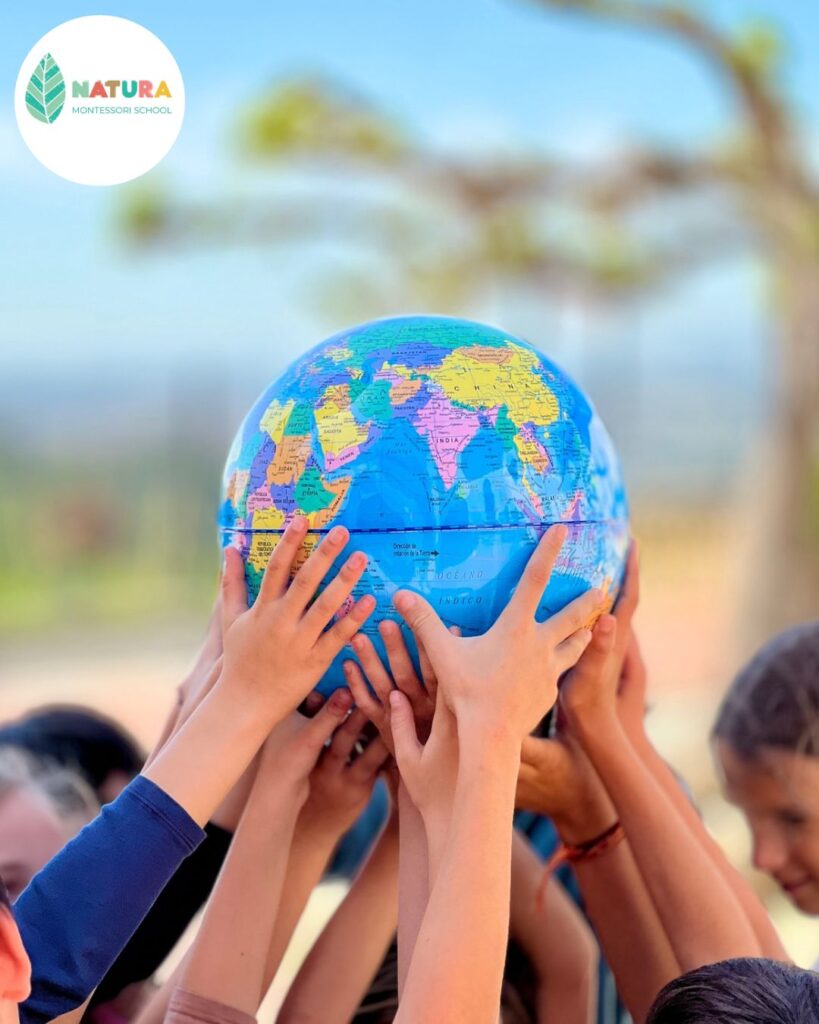 Niños de Natura Montessori School sosteniendo un globo terráqueo en el exterior