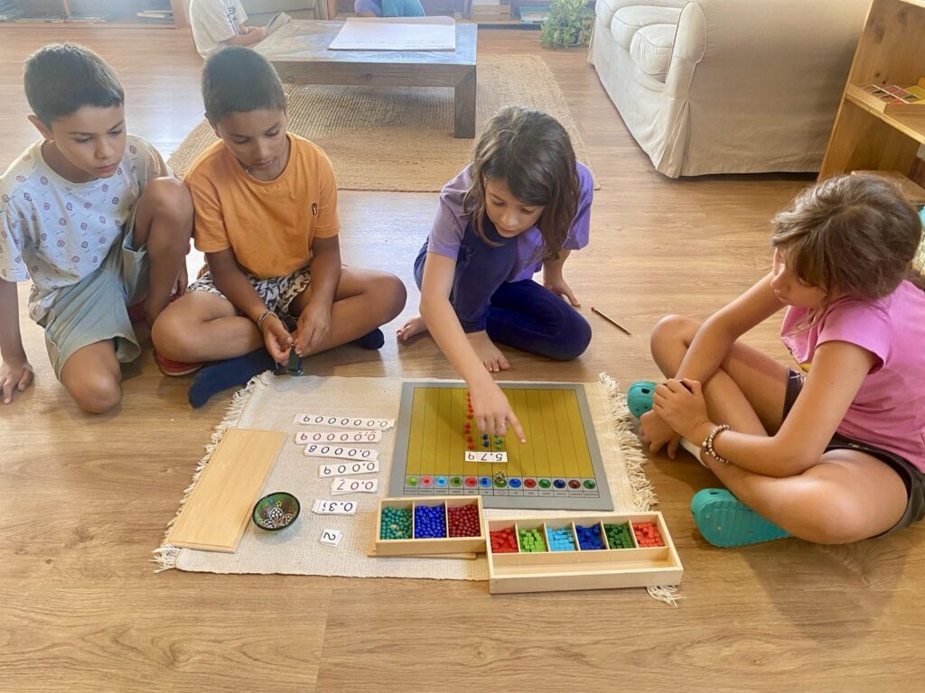 Grupo de niños trabajando juntos con materiales matemáticos Montessori